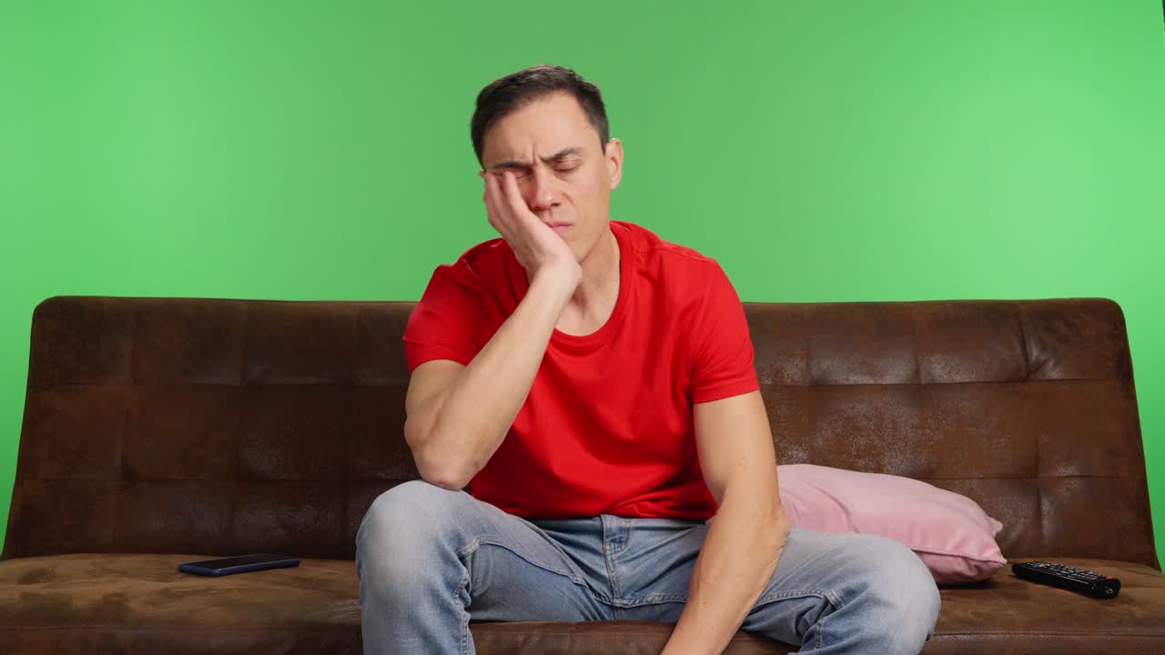 Sad and depressed man trying to watch a movie