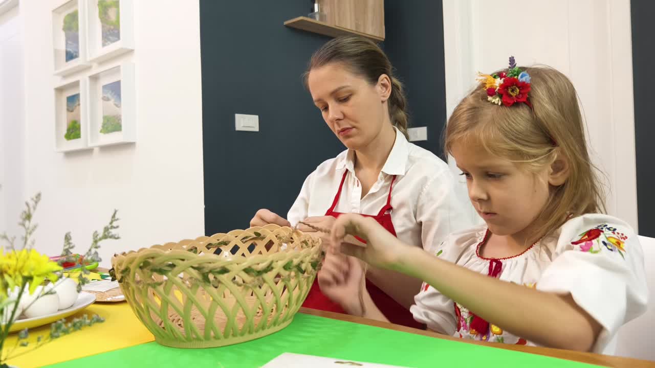 어머니 와 딸 이 부활절 바구니 를 장식 하고 있다