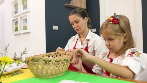 madre e hija decorando una canasta de pascua