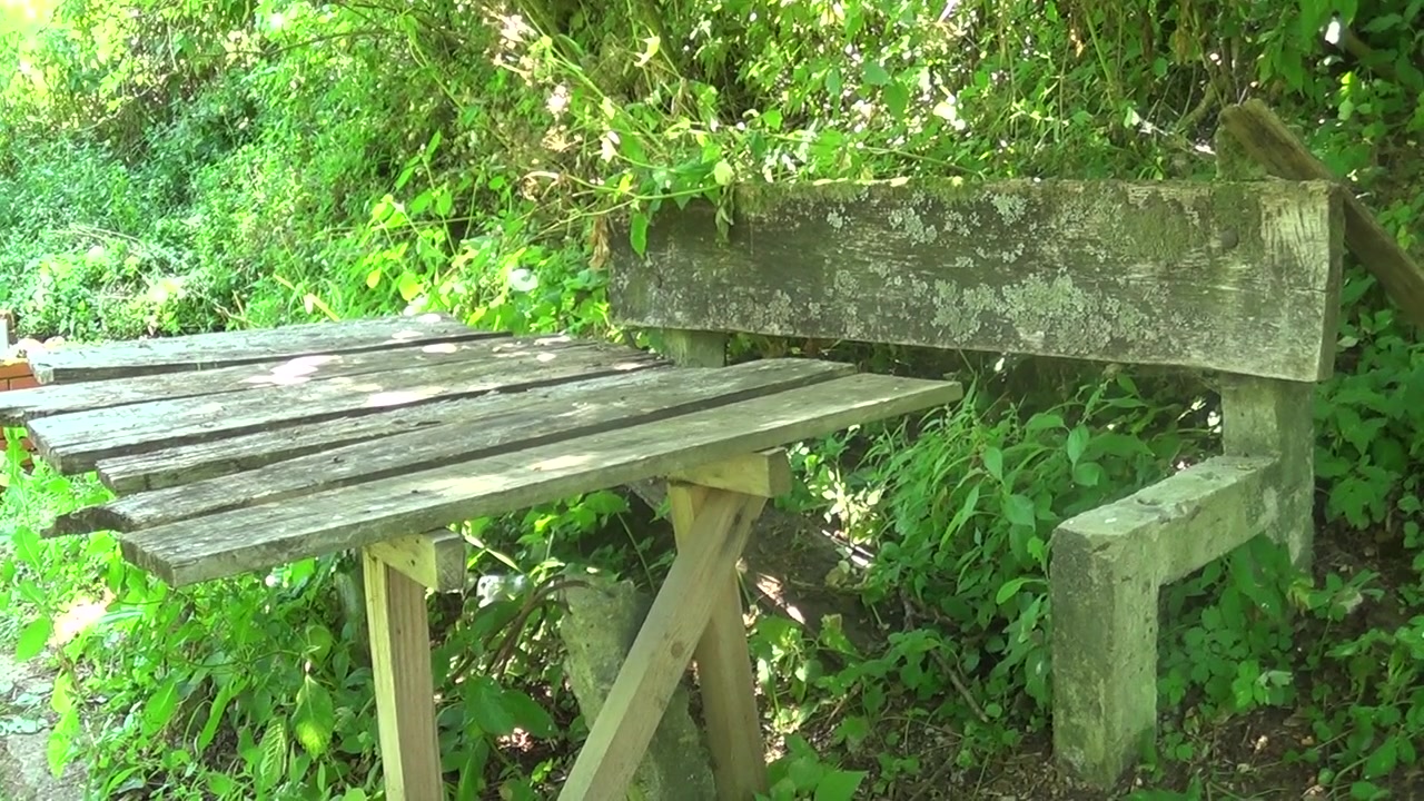 Old and abandoned concrete bench with table