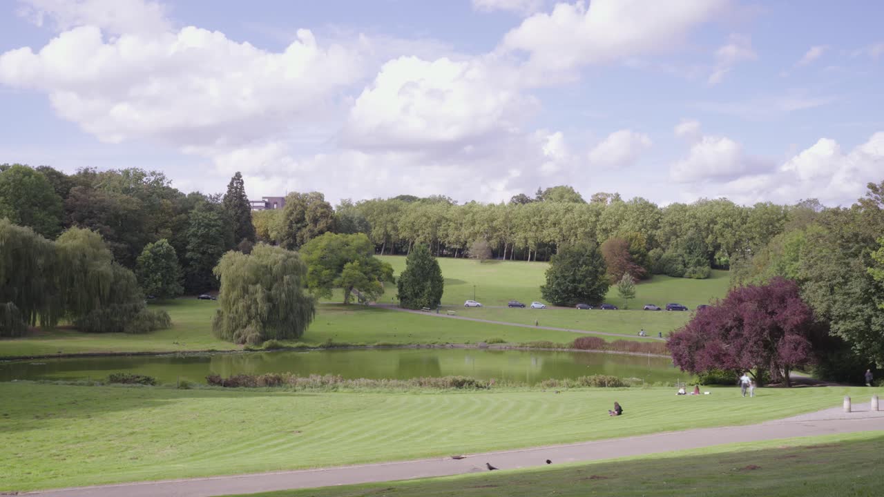 el tiempo del horizonte verde de bruselas cae con tráfico en la carretera y parque con gente