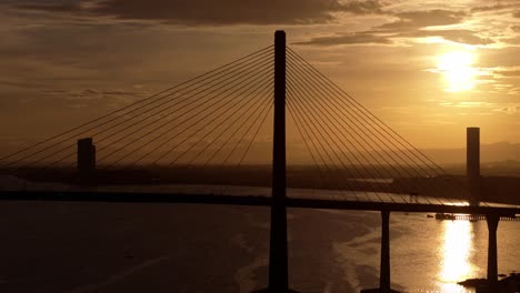 cebu cordova link expressway, silhouetted against a dramatic orange sunset