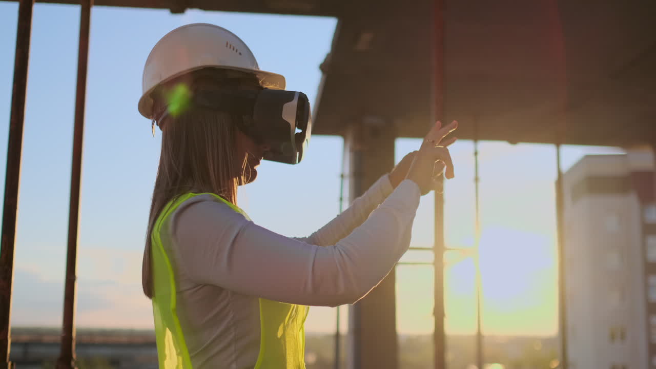 mujer ingeniera experta constructora en vr gafas y casco comprueba el progreso de la construcción de rascacielos moviendo sus manos al atardecer visualizando el plan del edificio
