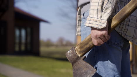 Vista-Cercana-De-La-Mano-Del-Hombre-Sosteniendo-El-Hacha-En-El-Campo