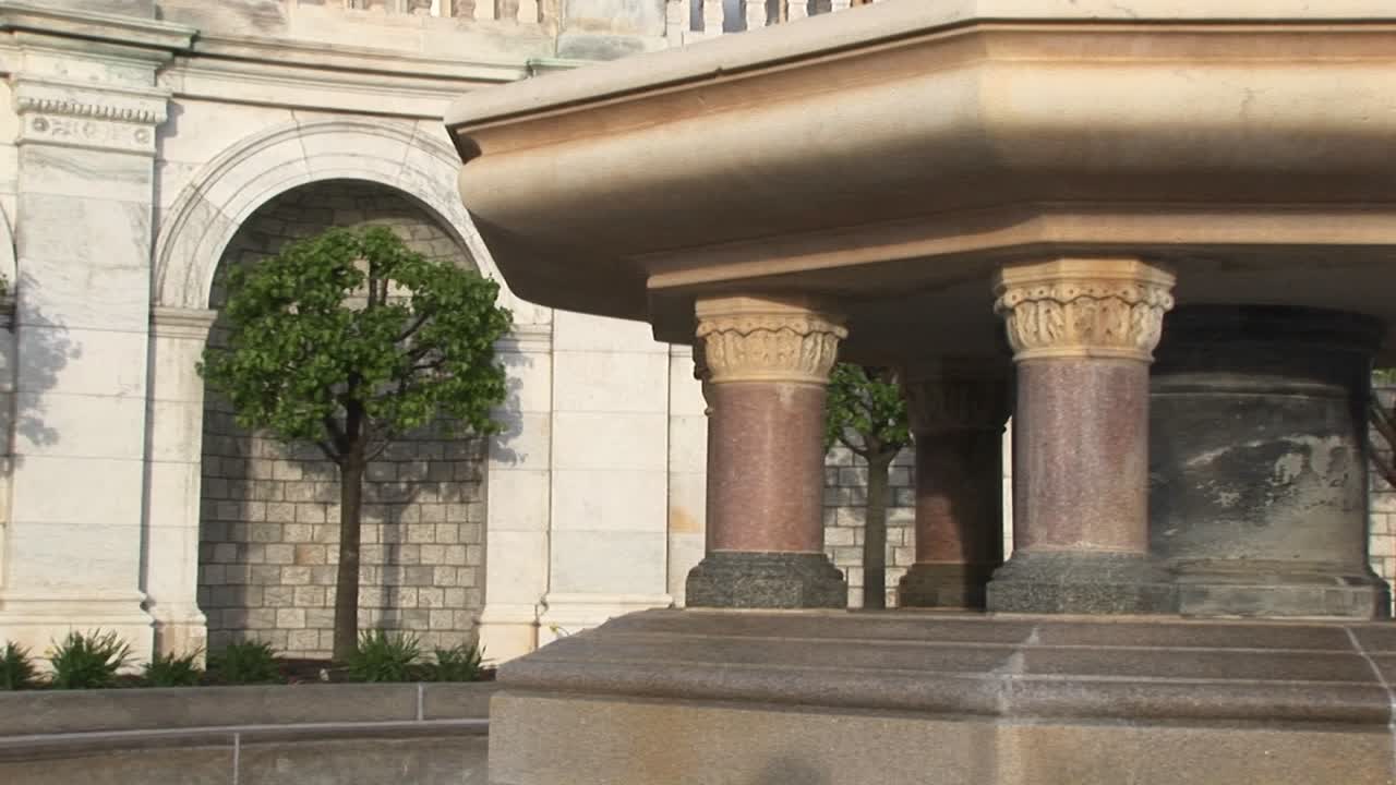 카메라는 거대한 분수의 바닥에서 돔 꼭대기에 있는 무장 자유의 주철 동상까지 미국 국회의사당 건물의 정면을 패닝합니다.