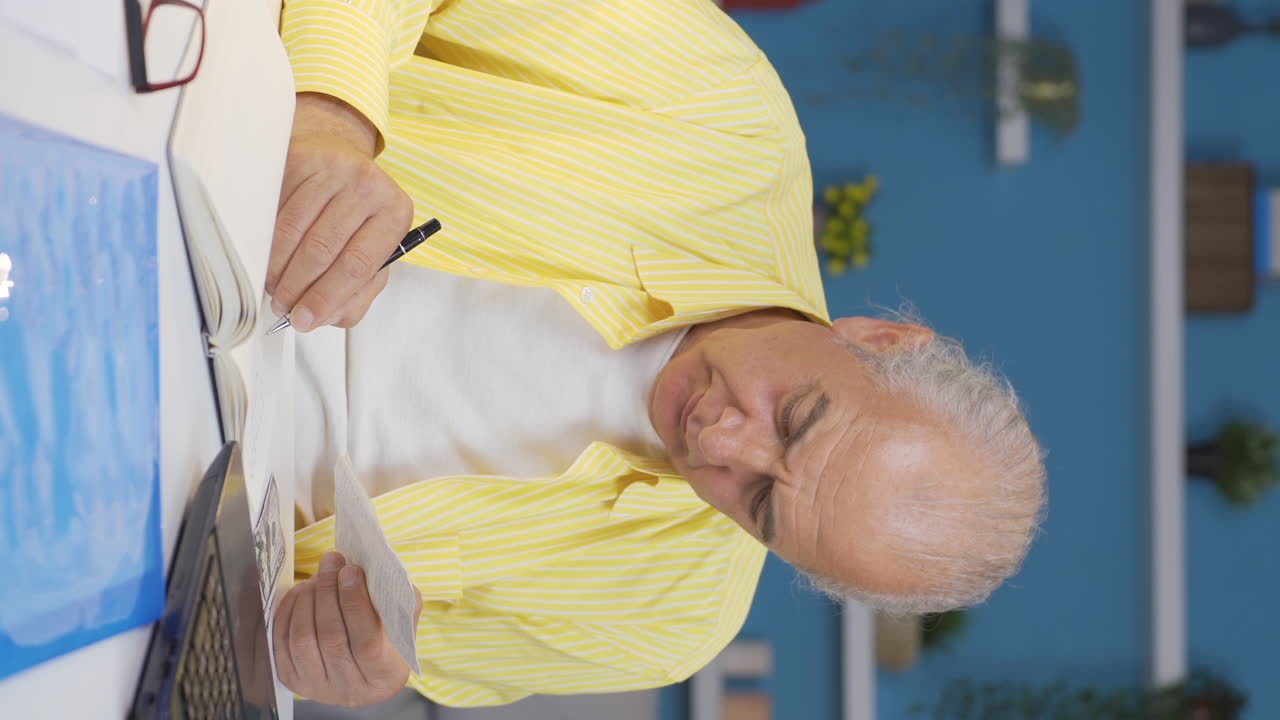 홈 오피스 직원의 수직 비디오  ⁇ 은이가 청구서 계산을 합니다.