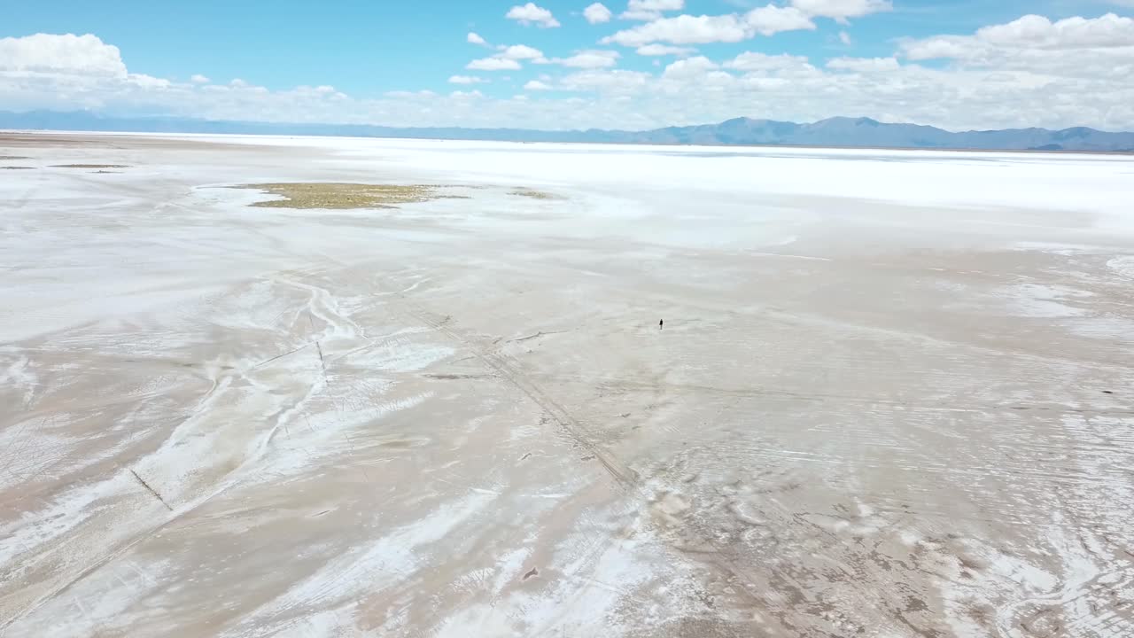 Aerial View of Female Photographer in Endless Landscape of Salt Flat, Argentina