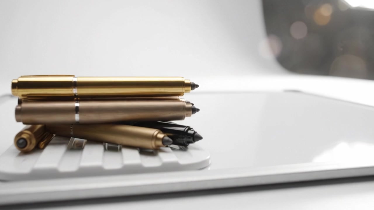 Una vista ravvicinata di eleganti penne metalliche su una superficie di scrivania bianca minimalista con uno sfondo sfocato e morbido, perfetto per gli appassionati di cancelleria e dell'estetica da ufficio.