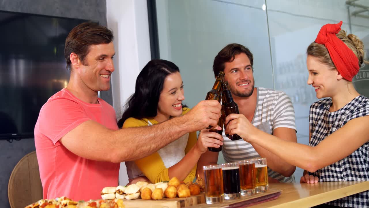 grupo de amigos brindando una botella de cerveza 4k