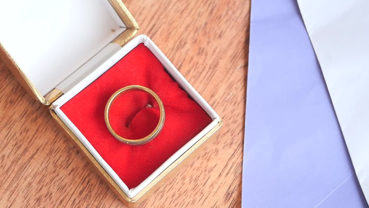 Woman's Hand Placing a Ring in a Red Box