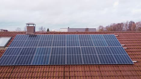 Carro-Aéreo-Hacia-Un-Conjunto-De-Paneles-Solares-Instalados-En-El-Techo-De-Una-Casa-Grande-Y-Moderna