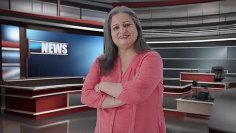 retrato de una feliz periodista india de alto rango de pie con las manos cruzadas