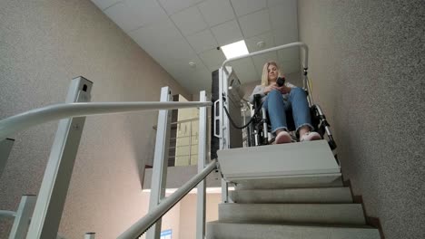una niña en silla de ruedas sube las escaleras sin esfuerzo usando un ascensor de escaleras.