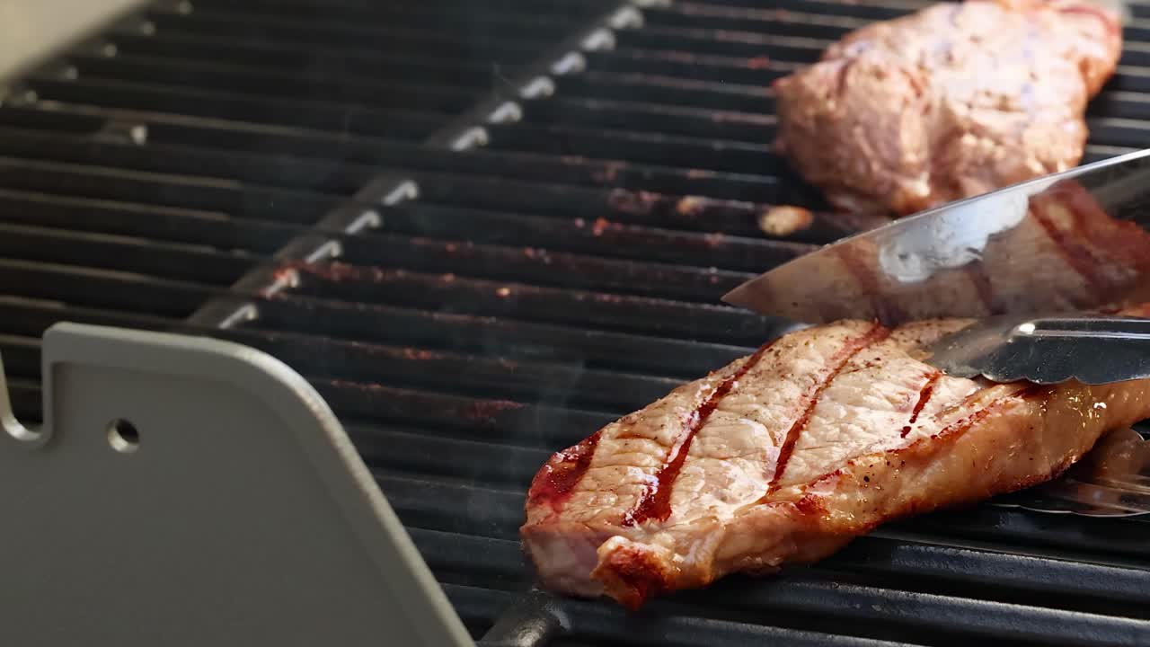 Hands expertly grill beef steaks on a barbecue, showcasing cooking techniques in a sunlit outdoor setting