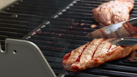 hands expertly grill beef steaks on a barbecue, showcasing cooking techniques in a sunlit outdoor setting