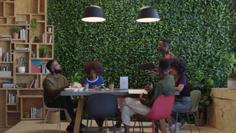 young black business people meeting team leader man sharing corporate documents colleagues working together on creative project brainstorming ideas in trendy office