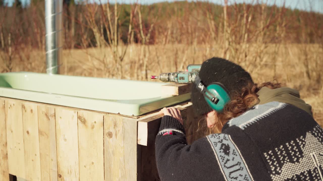 человек в процессе строительства ванны на открытом воздухе - вблизи