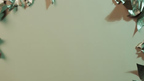 video of halloween autumn metallic leaves with copy space on green background