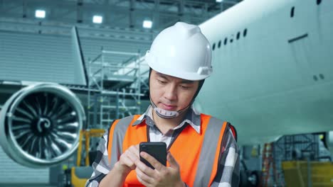 técnico de mantenimiento de aeronaves que utiliza un teléfono inteligente