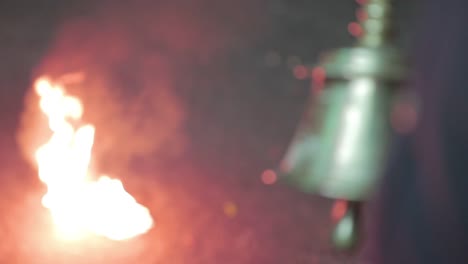 close up of hand ringing metal bell in indian ritual