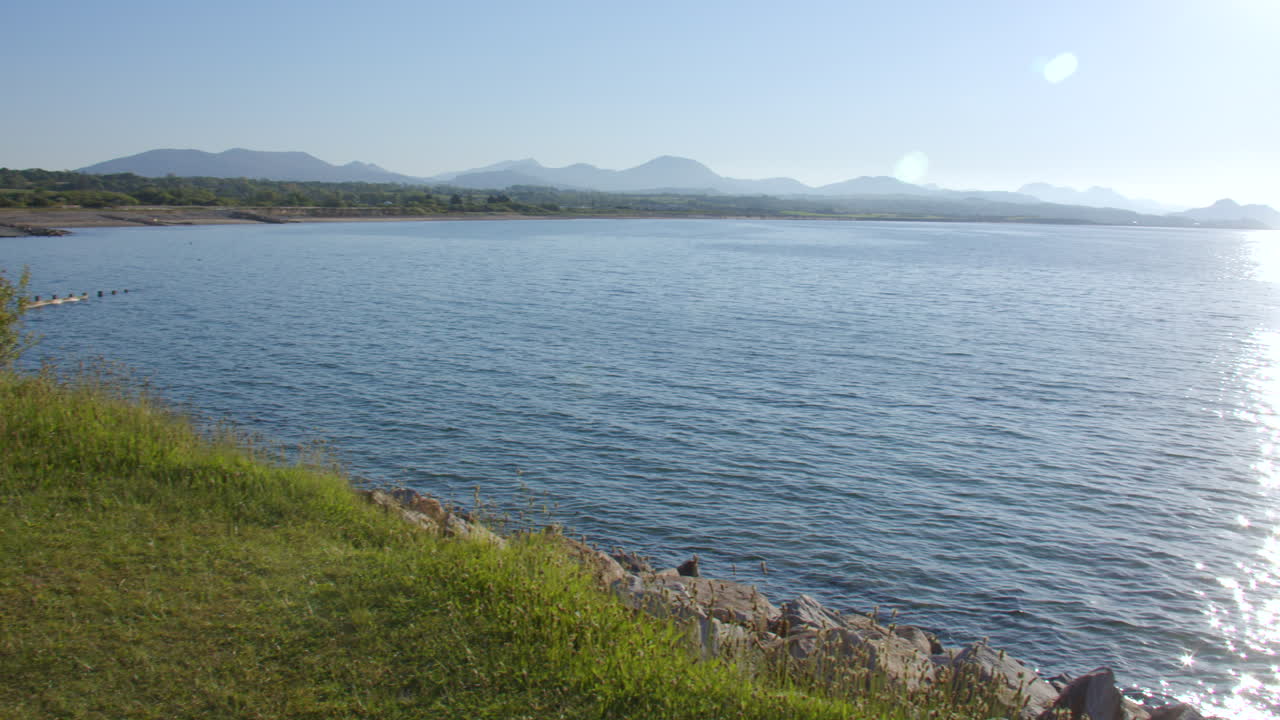 Panning left to right Extra Wide shot of the rocky Shoreline at Hafan y Môr on Pen-y-chain, Pwllheli