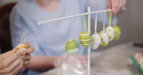 Senior-Man-And-Granddaughter-Decorating-Table-With-Easter-Eggs-And-Easter-Decorations-2