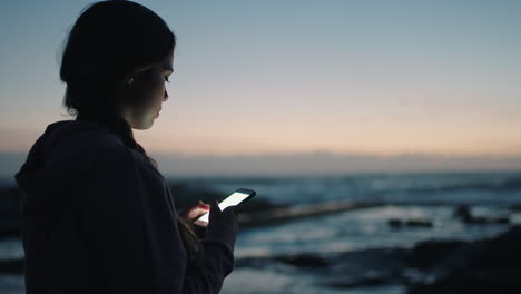 young woman texting by seaside beach waiting sunset sunrise