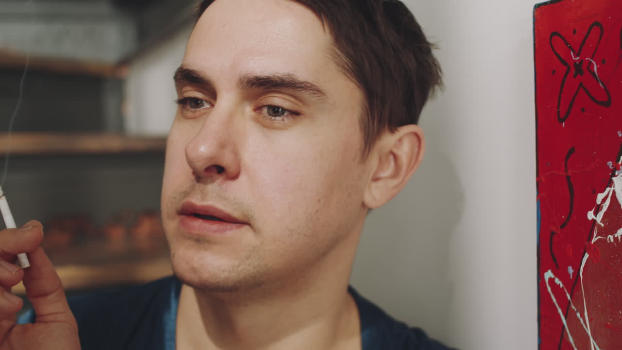 집에서 담배를 피우는 고민하는 트랜스젠더 남성