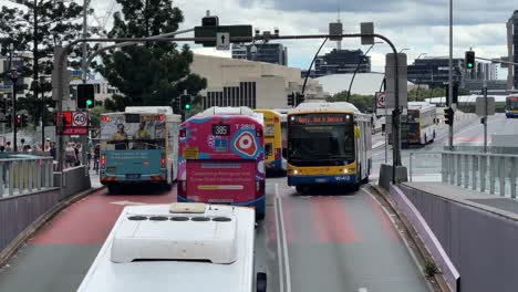 busy city bus traffics on bus-only road, passengers commuting with public transportation on south east busway across the bridge at central business district of brisbane city, queensland, australia.