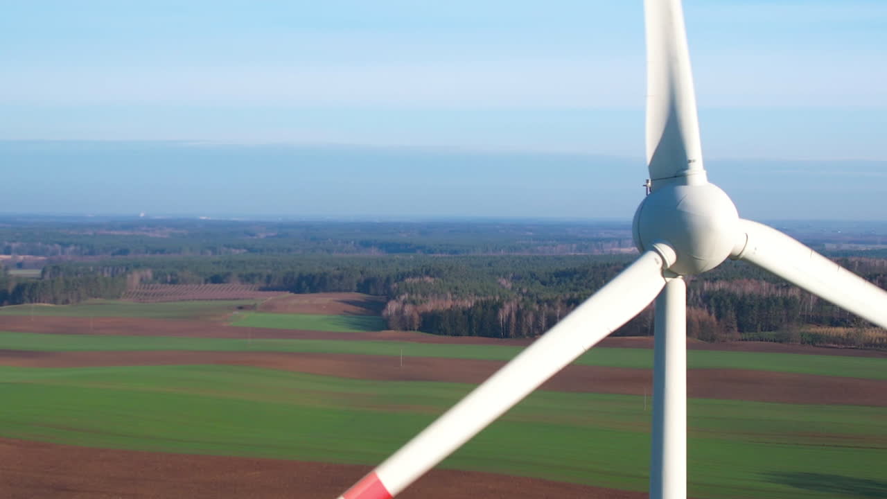 평평한 시골 풍경에서 해가 뜨는 동안 드론으로 발사 된 풍력 터빈 농장 - 근접