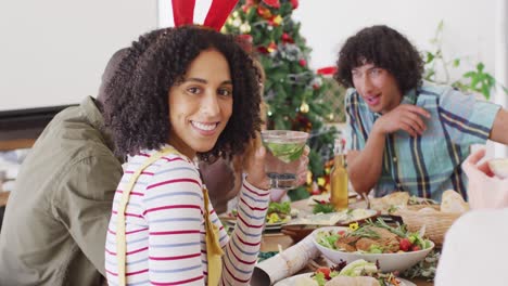 un grupo feliz de amigos diversos sentados a la mesa y cenando juntos