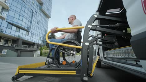 un hombre en silla de ruedas en un ascensor de un vehículo para personas con discapacidad. equipo de elevación para personas con discapacidades - hombre en silda de ruedas cerca del vehículo
