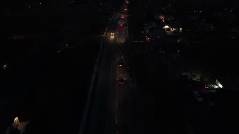 driving cars on main street of housing area at night