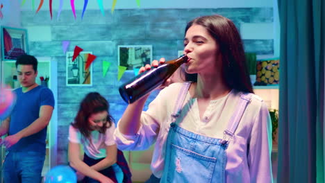 zoom in shot of beautiful girl drinking beer from the bottle