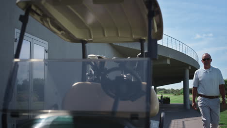 el golfista rico pone en marcha el motor del carrito de asiento en el club de campo.