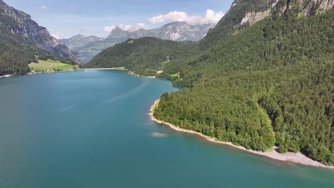 aérea - klöntalersee con costa boscosa y montañas en el cantón de glarus, suiza
