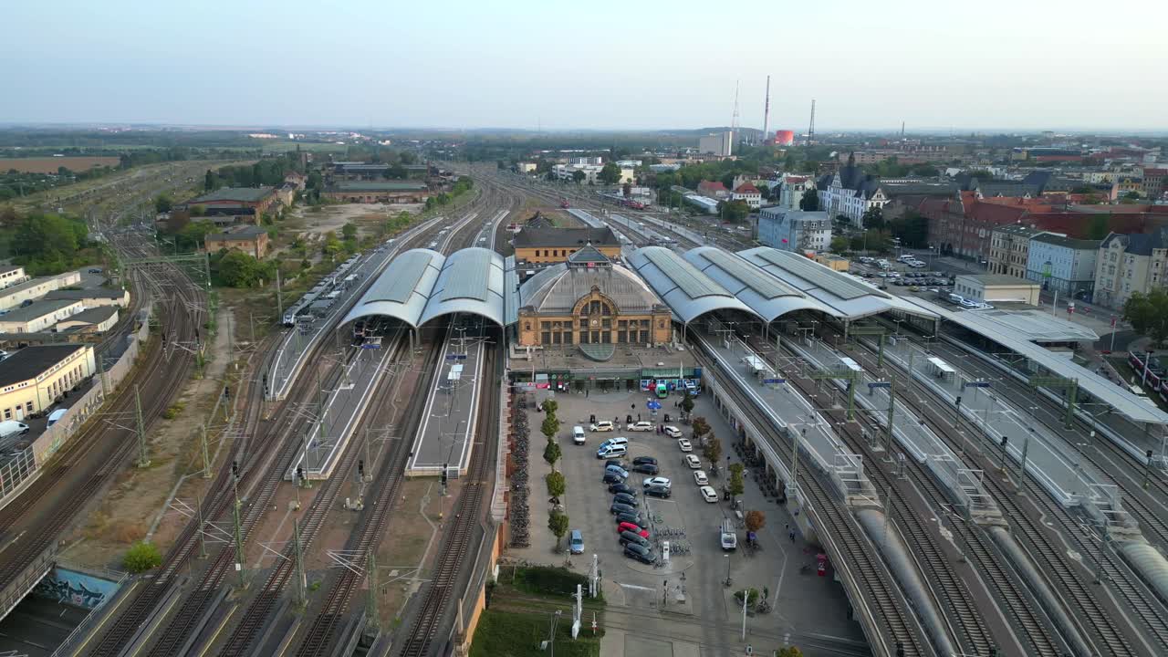 Aerial view of a modern train station with connecting tracks leading to suburbs and the city center. Unbelievable aerial view flight wide orbit overview drone
