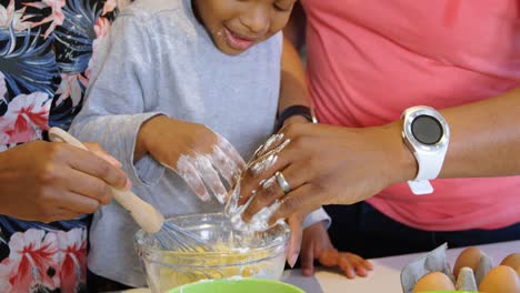 Father-and-son-pouring-flour-into-bowl-and-mother-whisking-eggs-4k