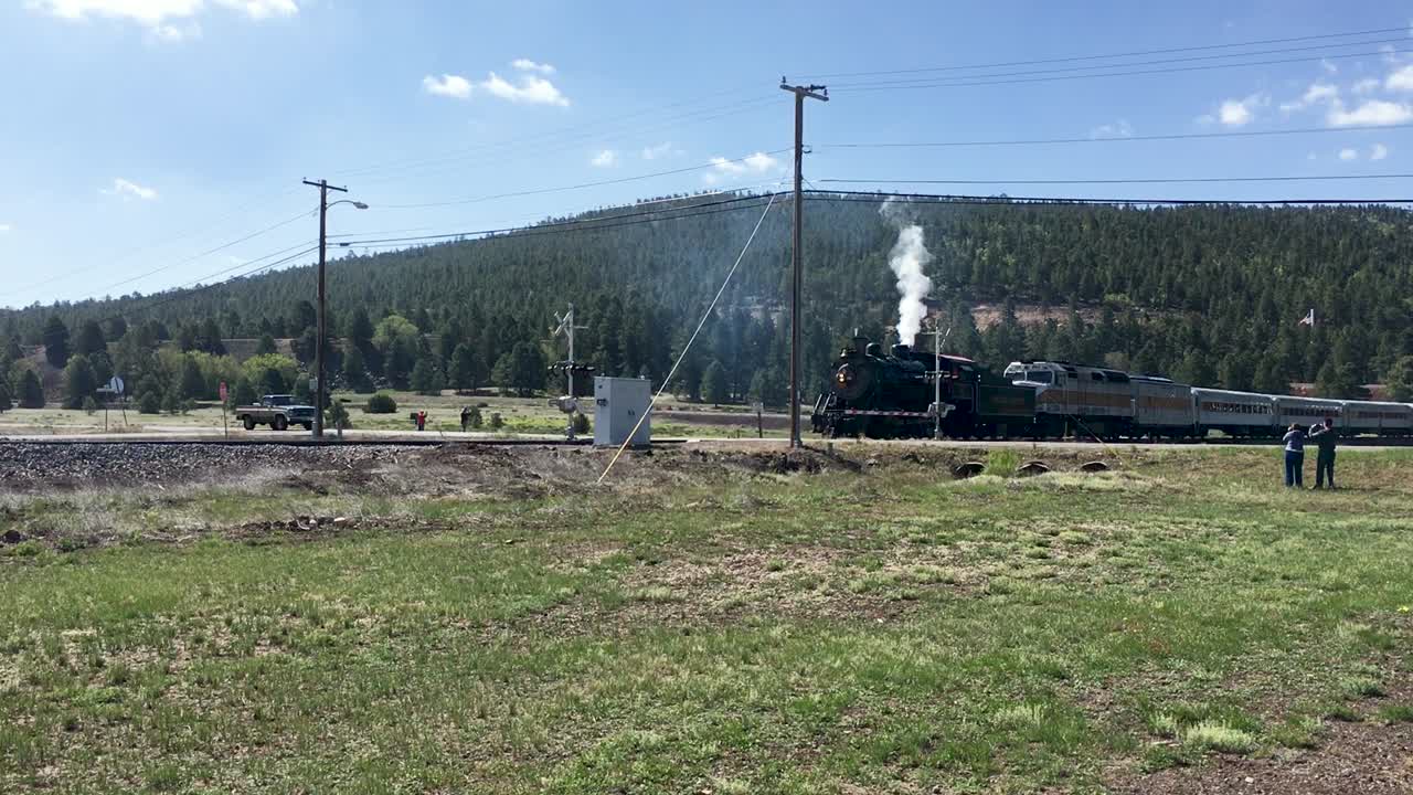 빈티지 스트림 엔진은 애리조나 주 깃대 교차점을 통해 현대식 기차 엔진과 자동차를 끌고 있습니다.