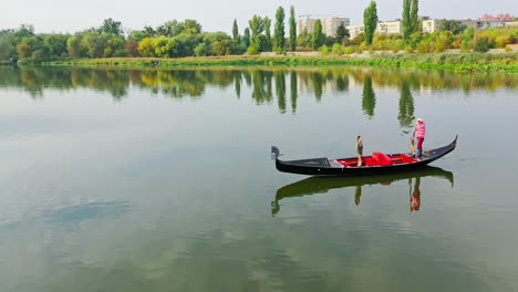 aerial view of traditional gondola. gondolier with his gondola paddles in city river