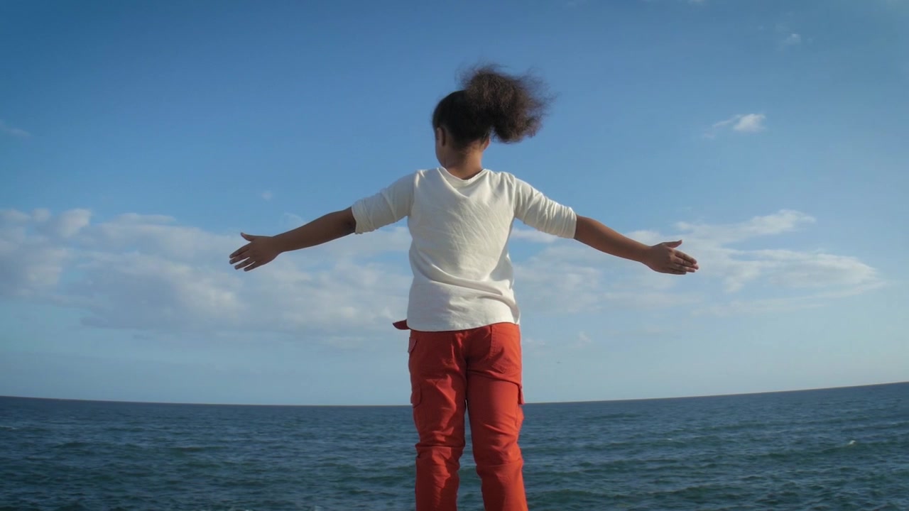 Girl arms open looking at sea, parallax right