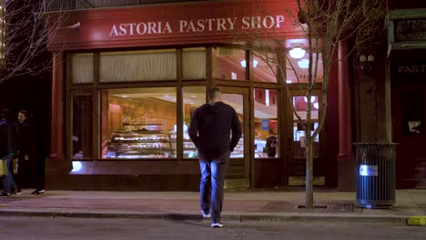 man walks across road to pastry shop