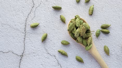 close up of cardamom on a spoon on table