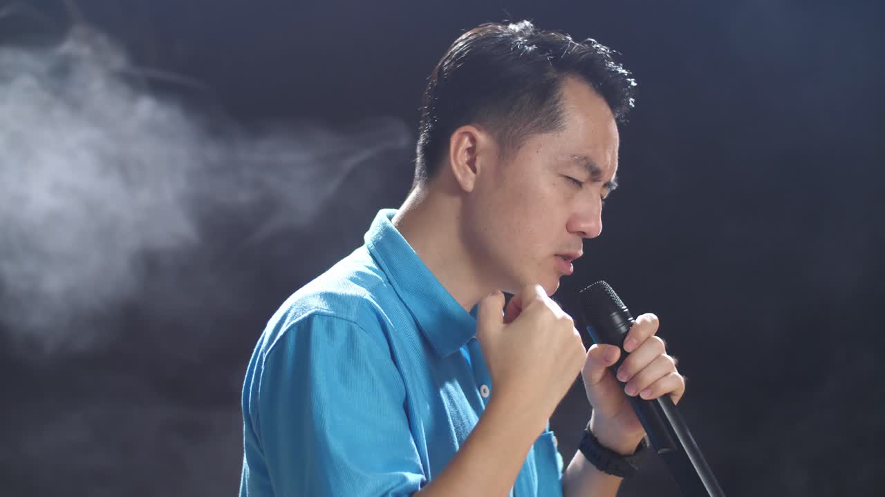 무대에서 마이크를 들고 노래하는 남자