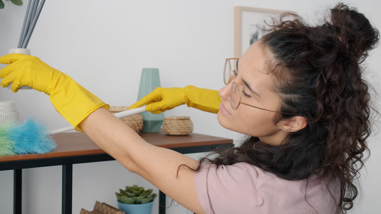 Woman cleaning shelves with a duster