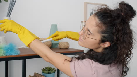 woman cleaning shelves with a duster