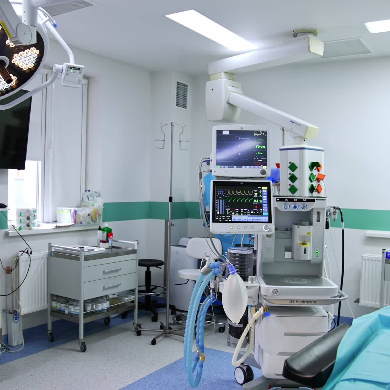 Contemporary well-equipped surgical room with diverse appliances. Lung ventilation machine switched on near the operational table