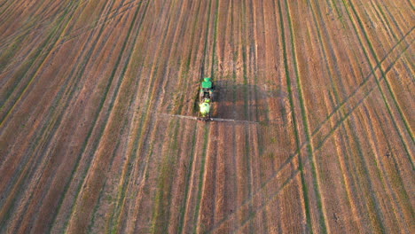 vista aérea de un tractor rociando plaguicidas en el campo