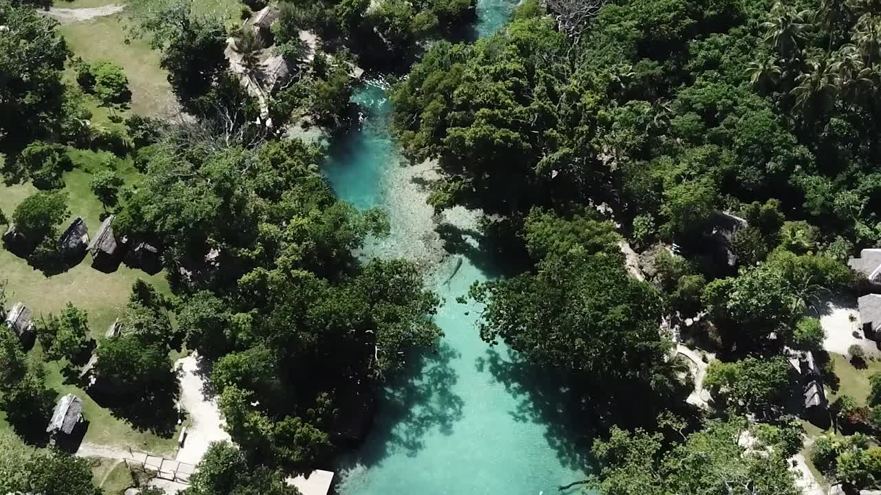 cabañas de la aldea de la isla de vanuatu en la laguna azul y el bosque verde tropical