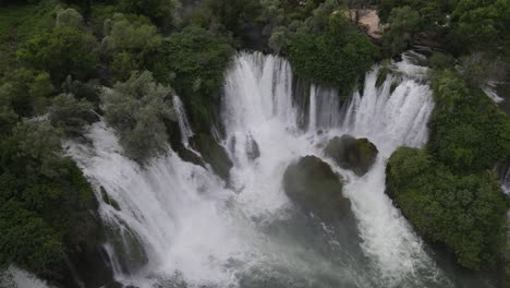 Vista-Desde-Arriba-Del-Agua-Que-Fluye-A-Través-De-Los-árboles-En-La-Cascada-De-Kravica-En-Bosnia,-La-Imagen-Creada-Por-El-Rápido-Flujo-De-Agua